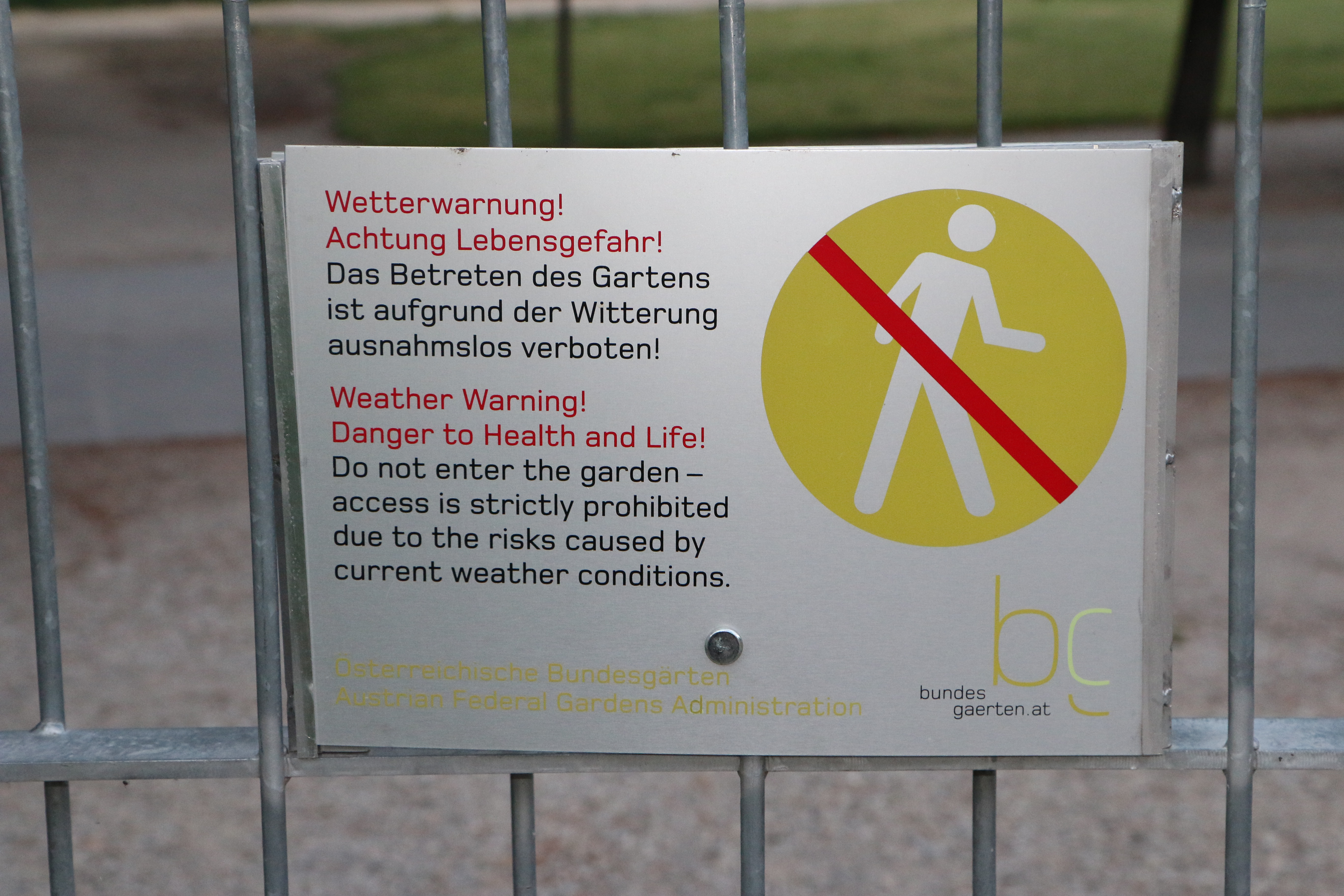 A sign with a “Weather Warning” and “no pedenstrians” symbol attached to a gate